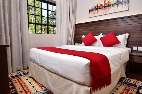 a bedroom with a large bed with red pillows at Palm Valley in Nairobi