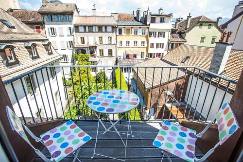patio con mesa y sillas en el balcón en Guest House Le Charlot, en Vevey