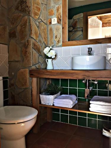 a bathroom with a sink and a stone wall at El Corral De Concejo in Horcajuelo de la Sierra