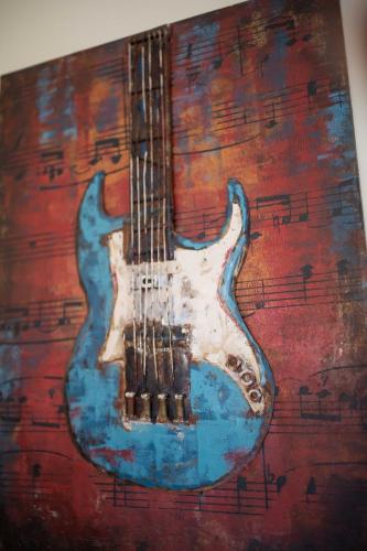 a painting of a guitar on a wall at The Oasis I, Portmore Country Club in Portmore