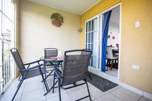 a dining room with a table and chairs on a balcony at The Oasis I, Portmore Country Club in Portmore