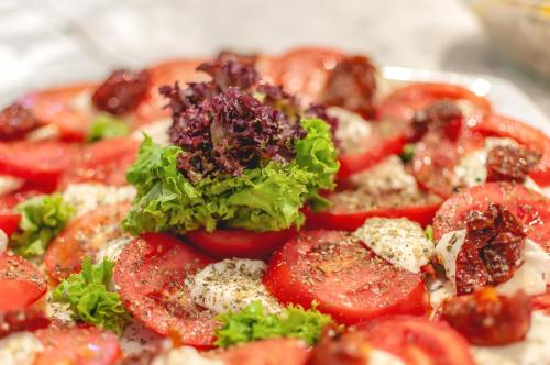 a plate of food with tomatoes and lettuce on it at Morska Osada domki blisko morza in Krynica Morska
