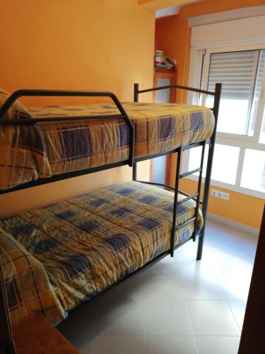two bunk beds in a room with a window at Apartamento centro in Antequera