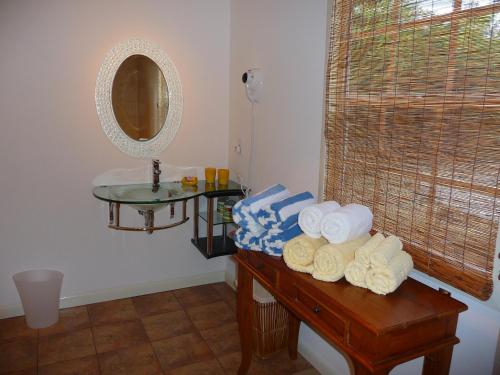 a bathroom with a table with towels and a mirror at Yepton Estate Cottages in Saint Johnʼs