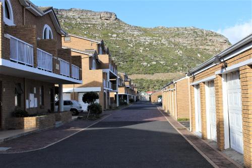 an empty street with a mountain in the background at South Peninsula Beach Apartment in Cape Town