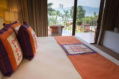 a bedroom with a bed with a view of a balcony at El Chante Spa Hotel in Jocotepec