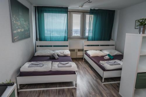 two beds in a room with blue curtains at FeWo Köln in Cologne