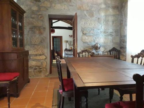 a dining room with a wooden table and chairs at Casa da Farmácia in Castanheiro