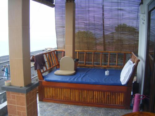 a porch with a bench on a balcony at Bubu Racok Homestay in Amed