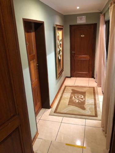 a hallway with a door and a rug on the floor at Marion Lodge in Johannesburg