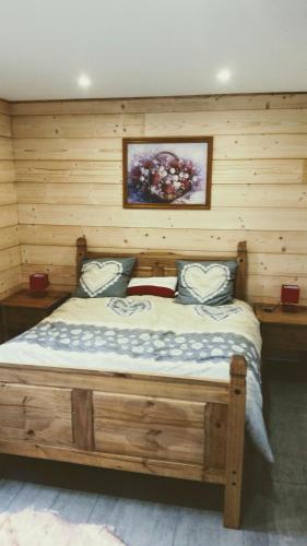 un lit dans une chambre avec un mur en bois dans l'établissement Gite châlet nature haute vosges, à Anould