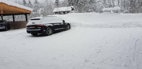 a car covered in snow in front of a house at Gästehaus Scharler in Neukirchen am Großvenediger