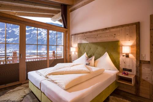 a bedroom with a large bed with a large window at Aparthotel Gallahaus in Zell am Ziller