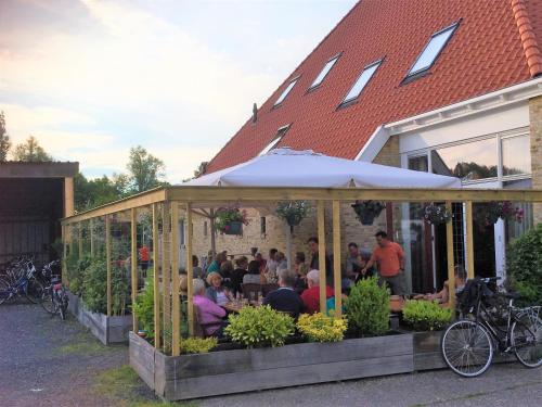 a group of people sitting at a restaurant in a greenhouse at Verblijf bij Bynt in Sneek