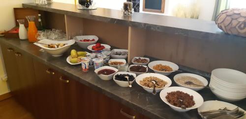 a counter with bowls of food and other dishes on it at Penzión Berg in Kežmarok