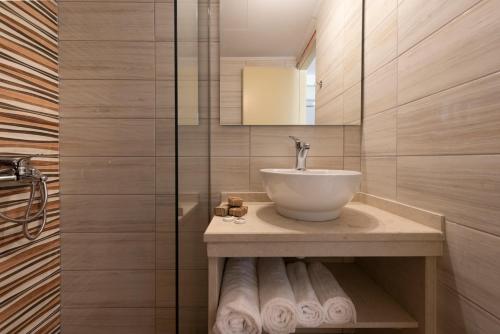a bathroom with a sink and a mirror at Erato Studios & Apartments in Kos Town