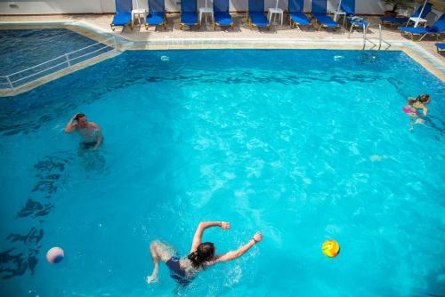 a group of people playing with a ball in a swimming pool at Erato Studios & Apartments in Kos Town