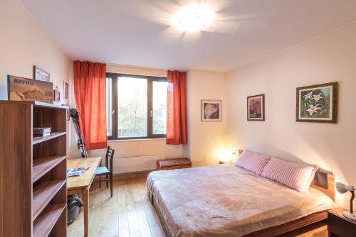 a bedroom with a bed and a desk and a window at Mountain Escape Bansko 1BR apartment in Bansko