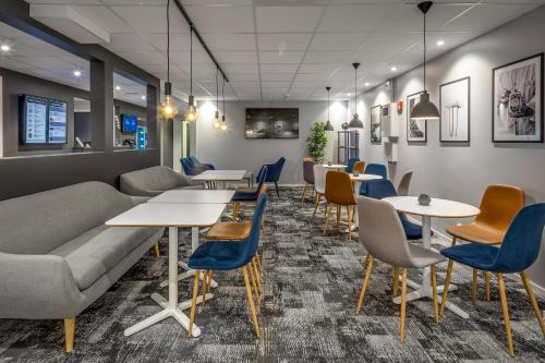 a waiting room with tables and chairs at Hotel Vindeus in Södertälje