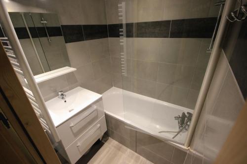 a bathroom with a sink and a tub and a shower at Appartement Le Thuria in Arc 1800