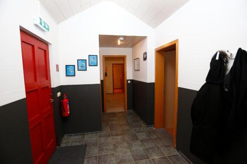 a hallway with red doors and black and white walls at Hellnafell in Grundarfjordur