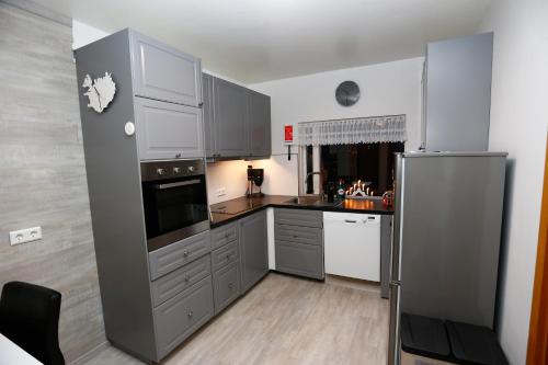 a kitchen with gray cabinets and a stainless steel refrigerator at Hellnafell in Grundarfjordur