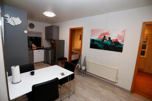 a living room with a white table and black chairs at Hellnafell in Grundarfjordur