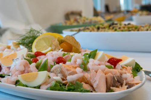 a plate of food with shrimp and vegetables on a table at Skærbæk Holiday Center in Skærbæk