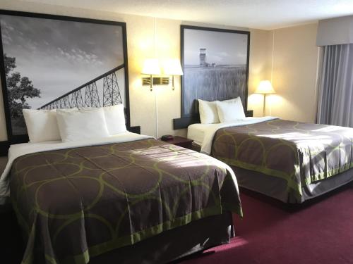 a hotel room with two beds and two lamps at Super 8 by Wyndham Lethbridge in Lethbridge