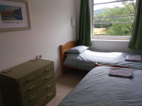 アンブルサイドにあるThrang Brow, Chapel Stileのベッドルーム1室(ベッド2台、ドレッサー、窓付)