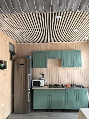 a kitchen with green cabinets and a refrigerator at RIVIERA in Lekechi