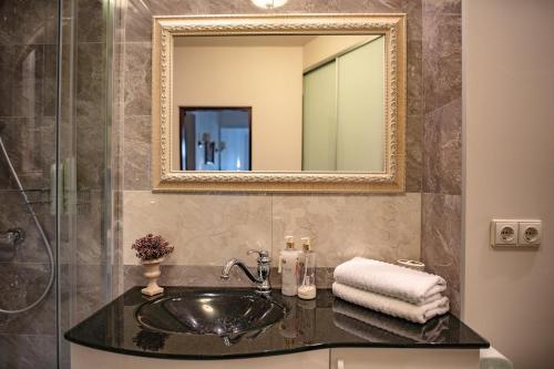 a bathroom with a sink and a mirror at Broadway apartament in Šiauliai