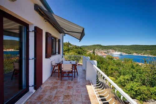 a balcony of a house with a table and chairs at LuceIssa (Beautiful Seaview Apartment) in Vis