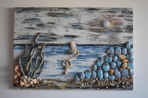a painting of a group of rocks and a necklace at Ariadne Beach in Plataniás