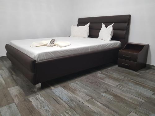 a bed with a black headboard and white sheets at Casa Cristina Corbu in Corbu