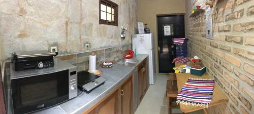 a kitchen with a counter with a microwave and a sink at Los Lapachos in Altos