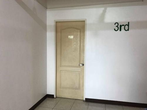 a white door in a room with a sign at Meaco Royal Hotel - Malabon in Manila