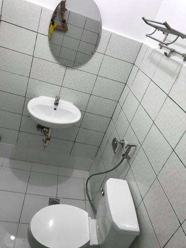 a white bathroom with a toilet and a sink at Meaco Royal Hotel - Malabon in Manila