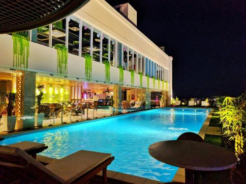 uma piscina em frente a um edifício à noite em Holiday One Can Tho Hotel em Can Tho
