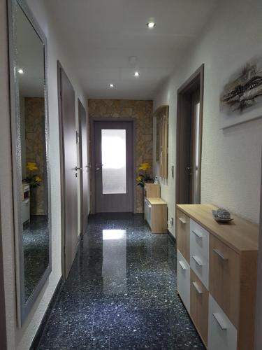 a bathroom with a hallway with a door and a mirror at FeWo Weitblick in Singen