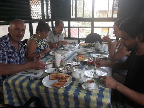 a group of people sitting around a table eating food at Jojies Homestay Fortkochi in Cochin