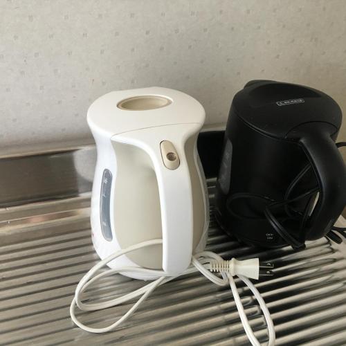 a white and black appliance sitting on a bed at Nanakuraso in Omachi