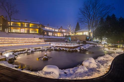 a pond covered in snow in front of a building at Evergreen Retreat-walk to National Forest Park, free pick up service in Zhangjiajie