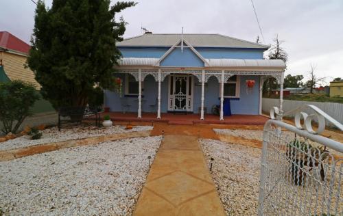
a large white house with a blue roof at Ella's Place in Broken Hill
