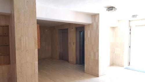 Habitación vacía con suelo de madera y pared con columnas. en apartosuite Sabana Grande, en Caracas