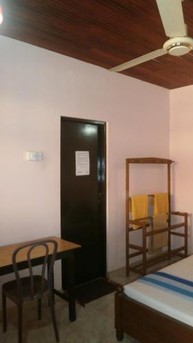 a room with a bed and a table and chairs at Sunny Lanka Guest House in Matara