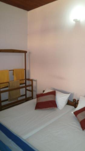 a bedroom with a white bed with two pillows at Sunny Lanka Guest House in Matara