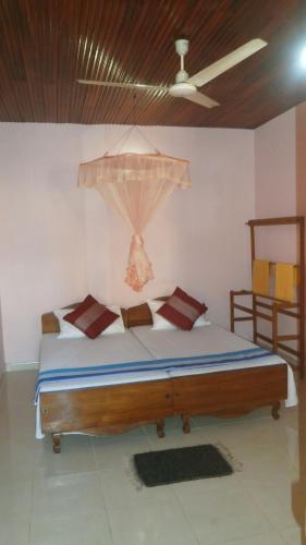 a large bed in a room with a ceiling at Sunny Lanka Guest House in Matara