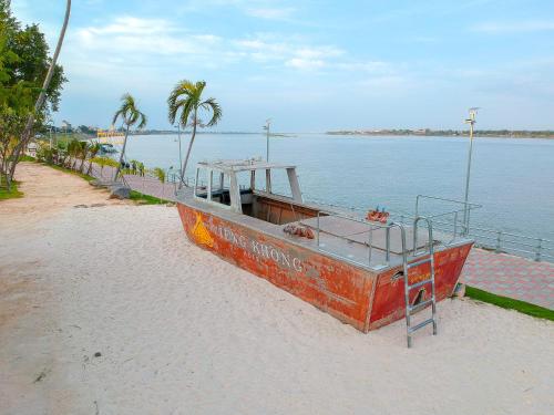 a boat sitting on the beach next to the water at Vieng Khong Hotel in Mukdahan