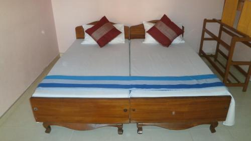 a bedroom with a large bed with red and blue pillows at Sunny Lanka Guest House in Matara